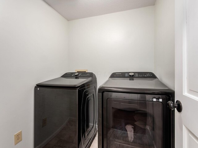 clothes washing area with washing machine and clothes dryer and laundry area