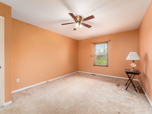 empty room featuring carpet flooring, visible vents, baseboards, and ceiling fan