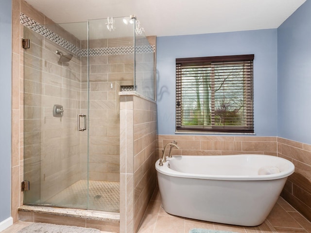 full bath with tile patterned floors, tile walls, a stall shower, and a soaking tub