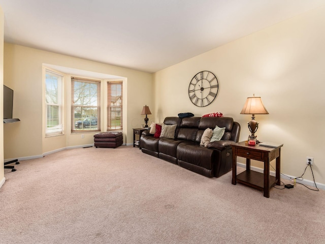 carpeted living area with baseboards