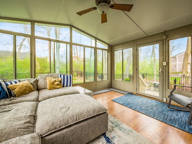 sunroom featuring ceiling fan, an outdoor hangout area, wood finished floors, and lofted ceiling