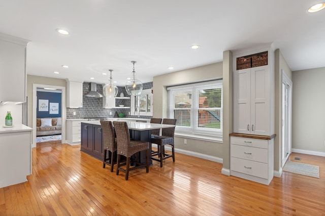 dining room featuring baseboards, light wood-style floors, and recessed lighting