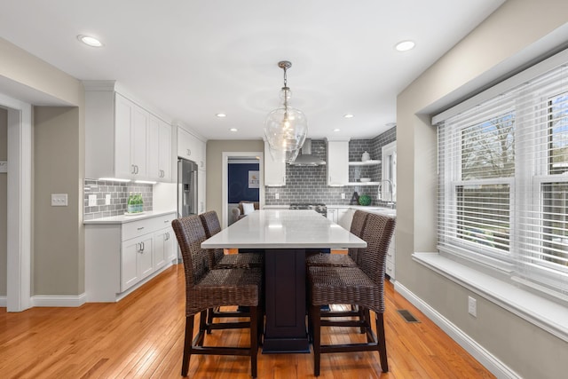 dining room featuring baseboards, recessed lighting, visible vents, and light wood-type flooring