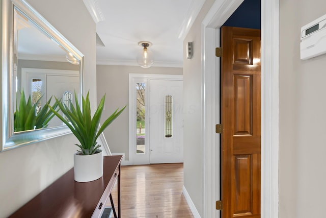 entrance foyer with wood-type flooring, baseboards, and crown molding