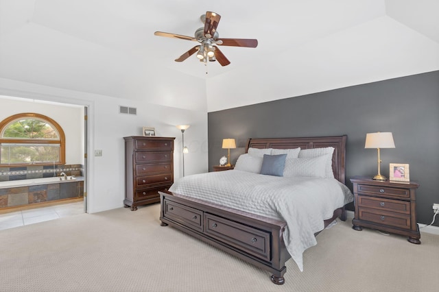 bedroom with vaulted ceiling, ensuite bathroom, ceiling fan, light carpet, and visible vents