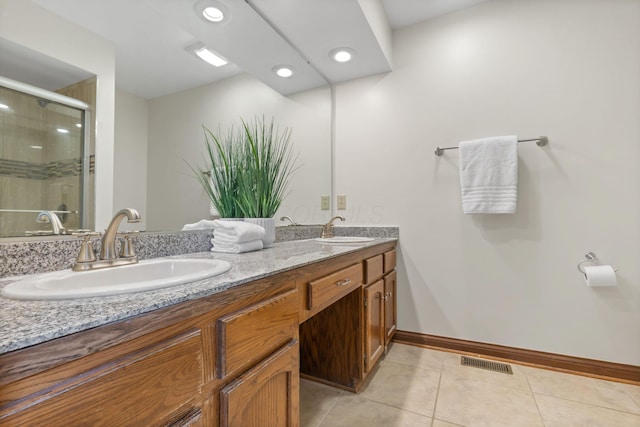 bathroom featuring visible vents, tile patterned floors, a stall shower, and a sink
