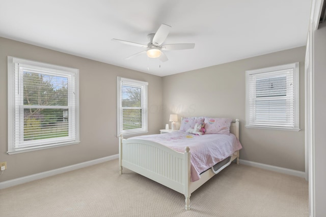 bedroom with ceiling fan, baseboards, and light colored carpet