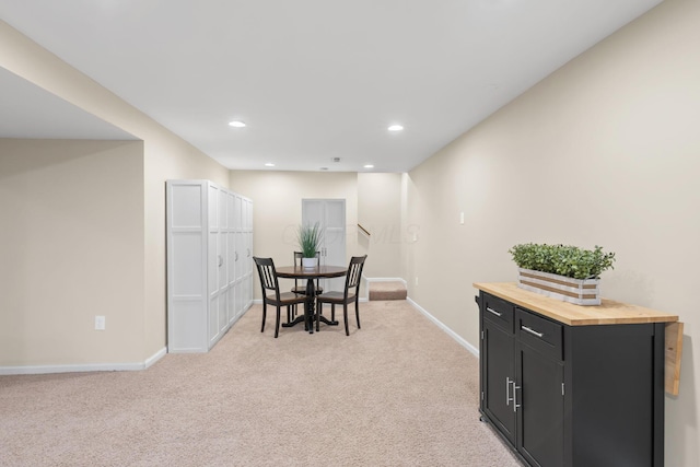 dining space with baseboards, recessed lighting, and light colored carpet
