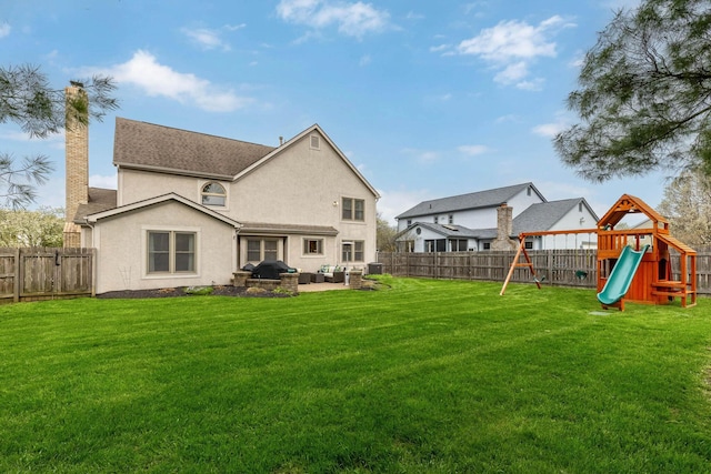 rear view of house featuring a chimney, an outdoor living space, a fenced backyard, and a playground