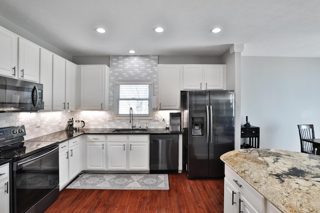 6185 Pollard Place Dr, Hilliard, OH 43026 - kitchen featuring a sink, black appliances, dark stone counters, dark wood-type flooring, and backsplash