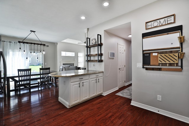 6185 Pollard Place Dr, Hilliard, OH 43026 - kitchen with white cabinets, baseboards, dark wood-style flooring, ceiling fan, and a fireplace