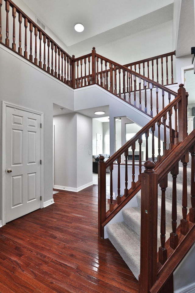 6185 Pollard Place Dr, Hilliard, OH 43026 - stairway featuring baseboards, hardwood / wood-style floors, and a towering ceiling