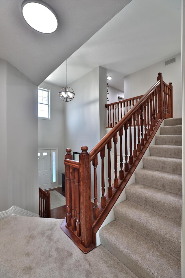 6185 Pollard Place Dr, Hilliard, OH 43026 - staircase featuring a notable chandelier, visible vents, baseboards, and carpet floors
