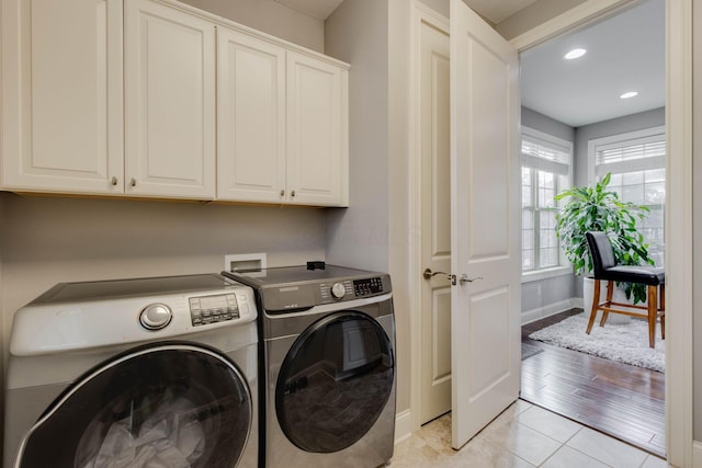 laundry area with recessed lighting, light tile patterned flooring, baseboards, cabinet space, and washer and clothes dryer