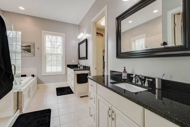 bathroom with a sink, two vanities, tile patterned flooring, and a garden tub