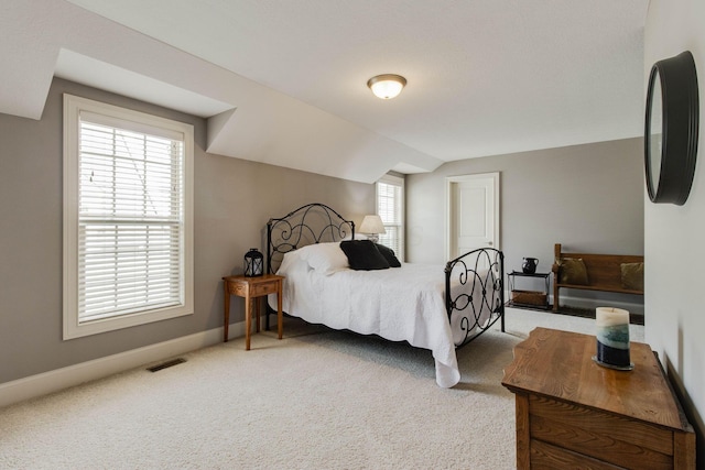 carpeted bedroom with visible vents, baseboards, and lofted ceiling