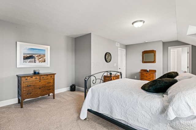 bedroom featuring light carpet, visible vents, baseboards, and vaulted ceiling