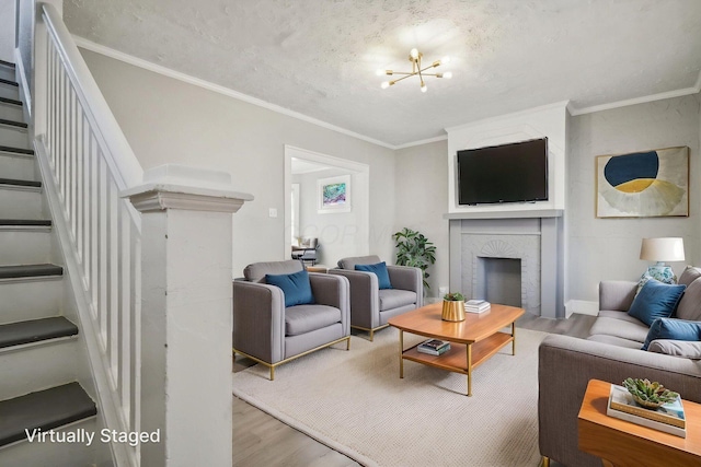 living area featuring wood finished floors, a notable chandelier, stairs, and a fireplace