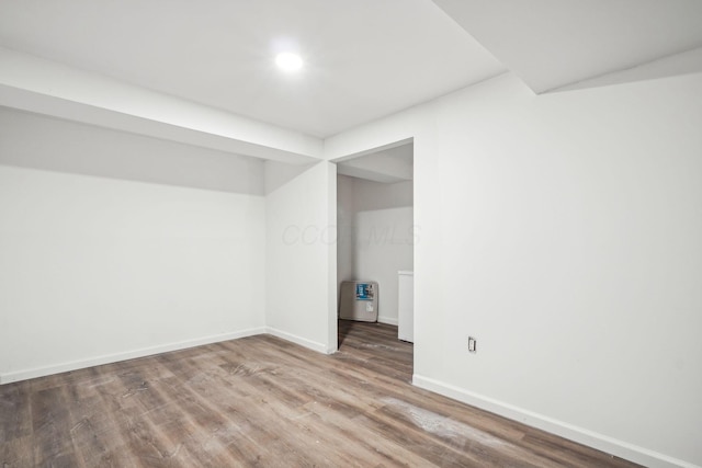 below grade area with baseboards and wood finished floors