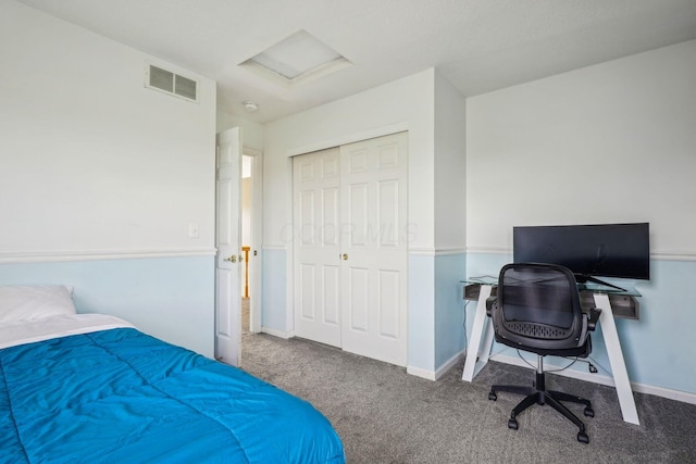 bedroom with visible vents, baseboards, a closet, attic access, and carpet flooring