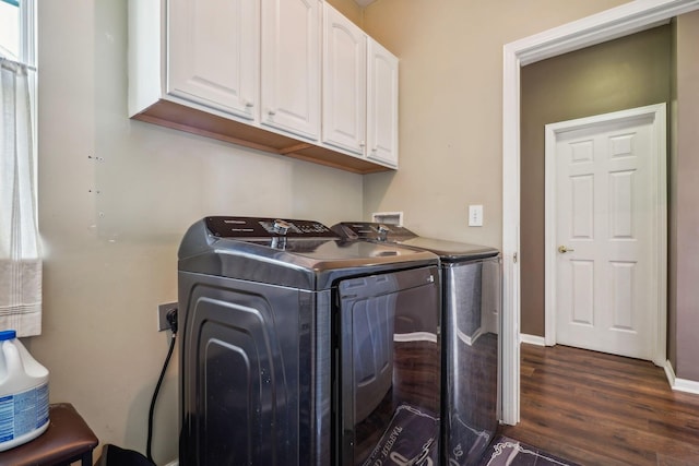 laundry area featuring dark wood-style flooring, baseboards, cabinet space, and washing machine and dryer