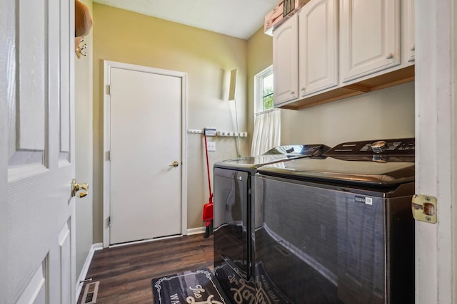 laundry area featuring dark wood-style floors, washing machine and dryer, visible vents, and cabinet space