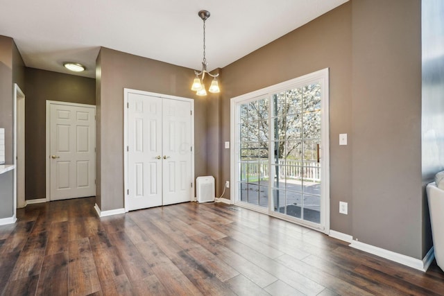 entrance foyer with a chandelier, baseboards, and dark wood finished floors