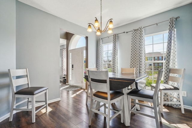 dining area with a chandelier, dark wood-style floors, and baseboards