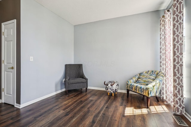 sitting room featuring visible vents, baseboards, and wood finished floors