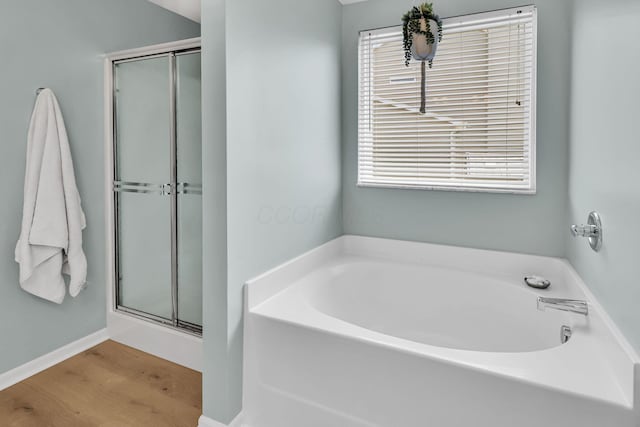 bathroom with a shower stall and a bath