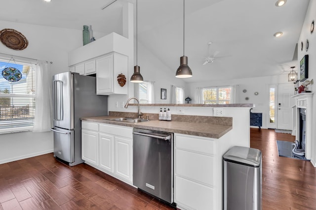 kitchen featuring ceiling fan, a wealth of natural light, a peninsula, appliances with stainless steel finishes, and a sink