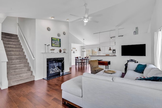 living area featuring a ceiling fan, a high end fireplace, stairs, dark wood-type flooring, and rail lighting