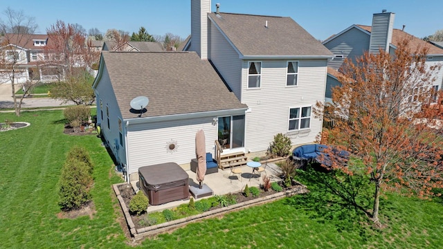 back of property featuring a patio, a chimney, entry steps, a yard, and a shingled roof