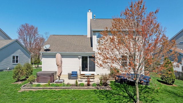 rear view of property with a hot tub, a yard, a patio area, a chimney, and a shingled roof