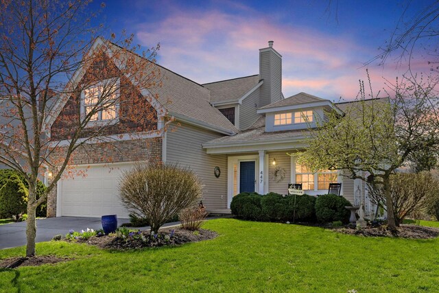 view of front of house featuring concrete driveway, a chimney, an attached garage, a shingled roof, and a lawn