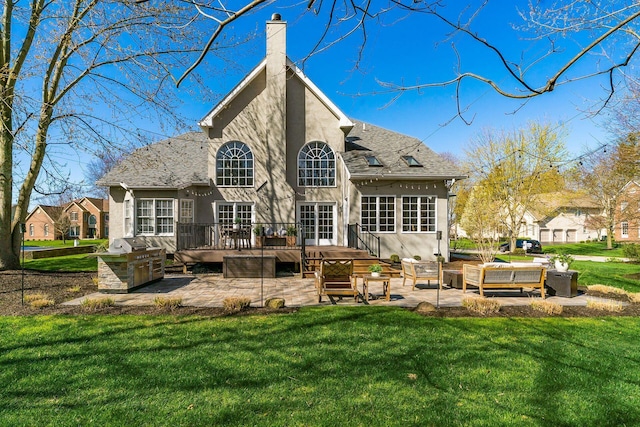 rear view of house featuring a patio area, stucco siding, a deck, and a lawn