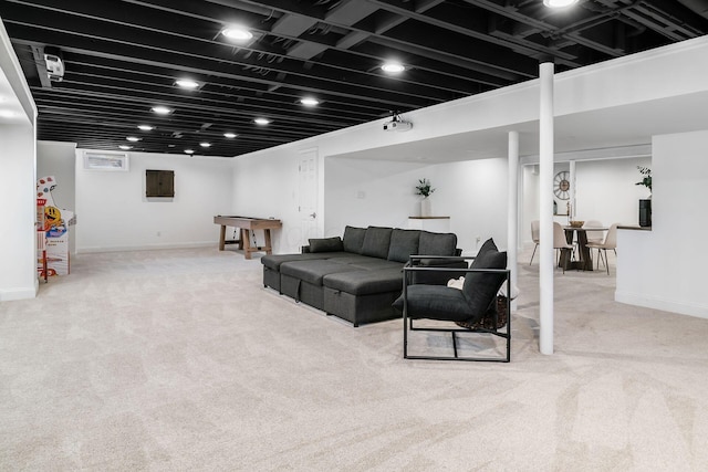 living area with baseboards, electric panel, and carpet floors