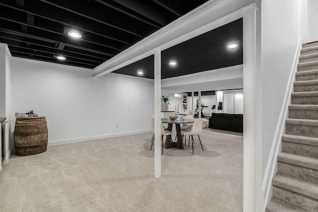 carpeted dining room with baseboards and stairway