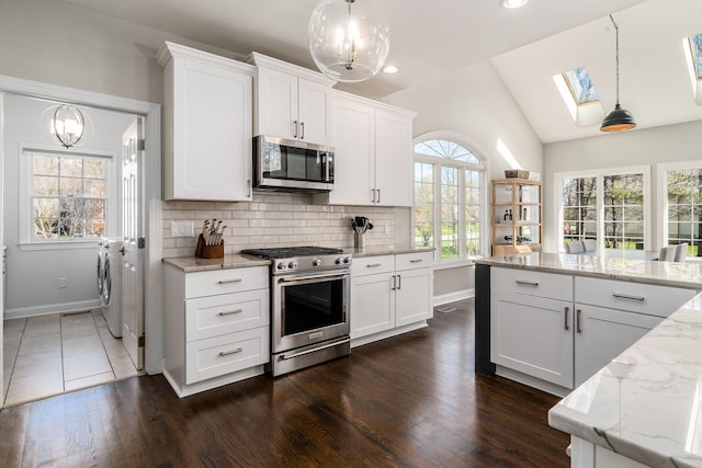 kitchen with stainless steel appliances, white cabinets, independent washer and dryer, and backsplash