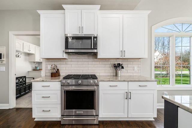 kitchen featuring stainless steel appliances, tasteful backsplash, white cabinetry, and light stone counters