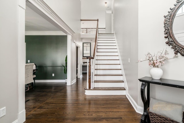 stairs with ornamental molding, baseboards, and wood finished floors