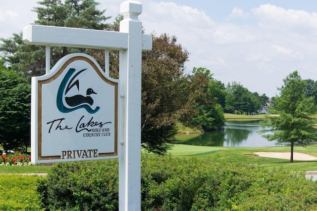exterior space featuring a water view, a yard, and view of golf course