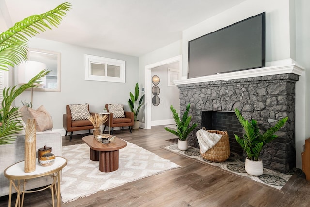 1069 Miller Ave, Columbus, OH 43206 - living area featuring wood finished floors, a stone fireplace, and baseboards