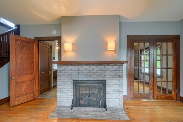 living room featuring baseboards, light wood finished floors, and a fireplace