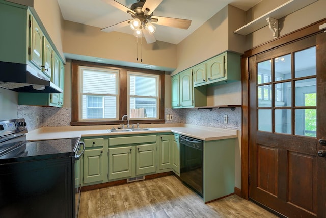 kitchen featuring tasteful backsplash, a sink, green cabinets, black appliances, and under cabinet range hood