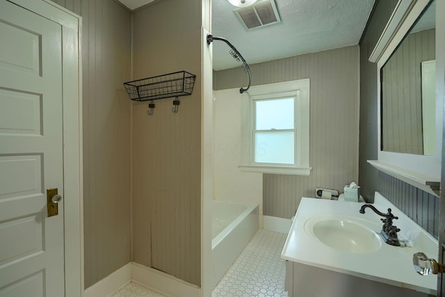 bathroom with visible vents,  shower combination, baseboards, and vanity