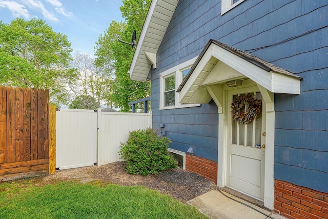 view of side of home featuring fence and a gate