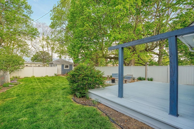 view of yard featuring an outbuilding, a wooden deck, and a fenced backyard