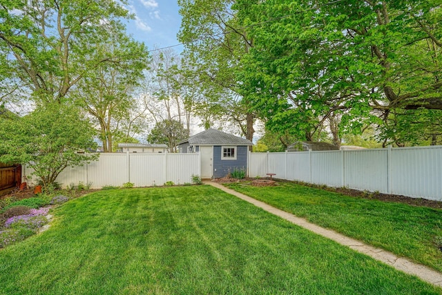 view of yard featuring a fenced backyard, an outbuilding, and a storage shed