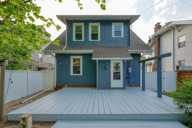 back of property featuring roof with shingles, a wooden deck, and a fenced backyard